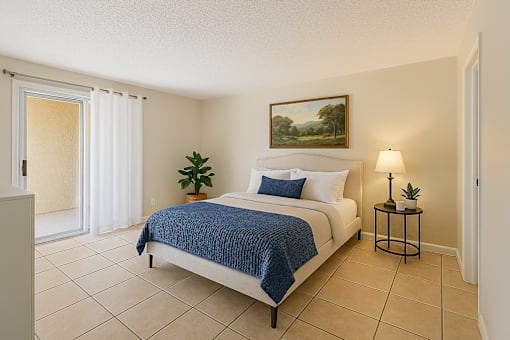 A bedroom with a bed, nightstand, and lamp.