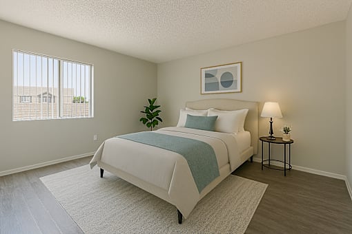 A bedroom with a bed, nightstand, and window.