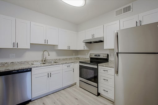 a kitchen with white cabinets and stainless steel appliances