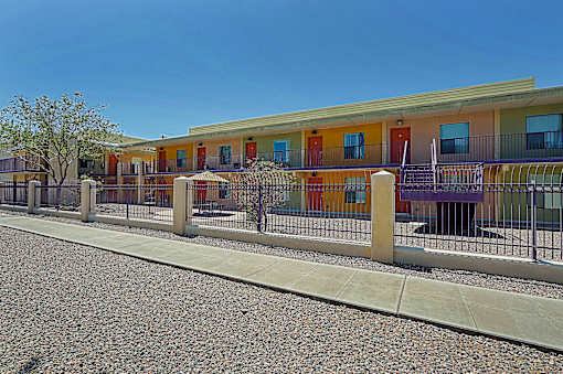 A row of colorful buildings with a fence in front.
