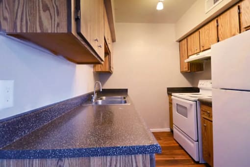 A kitchen with a white refrigerator and a white oven at Gilbert Square Apartments, Mesa, AZ