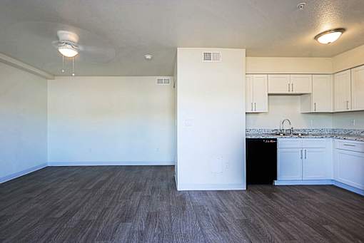 A kitchen with white cabinets and a black dishwasher.