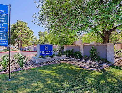 A sign for Northernly Accommodations is displayed in front of a tree.