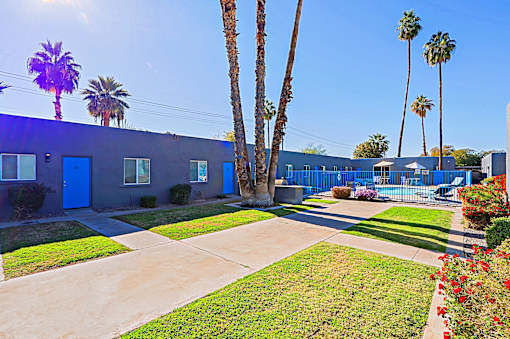A blue building with a concrete walkway in front of it.