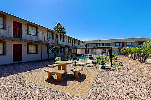 A sunny day at a courtyard with a table and chairs.
