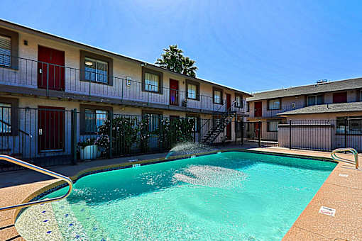 A swimming pool in front of apartment buildings.