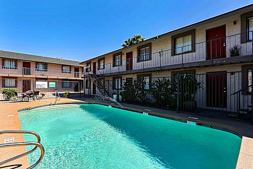 A swimming pool in front of apartment buildings.