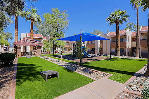A sunny day at the community park with a gazebo and a playground.