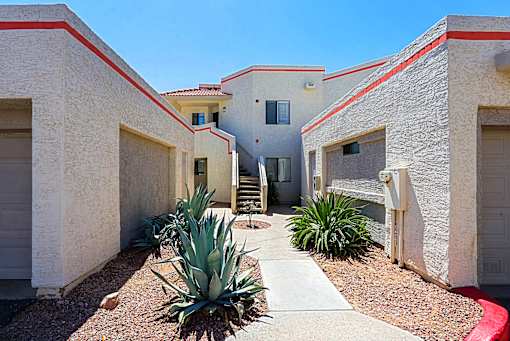 A concrete house with a red stripe on the roof.