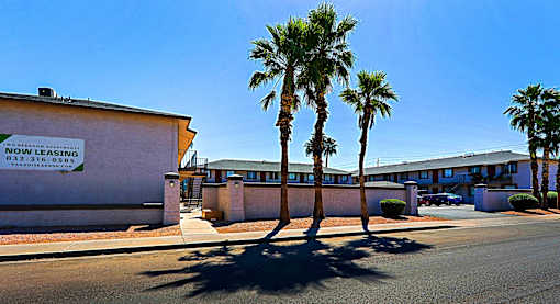 A building with a sign that reads "NOI TECH" and a phone number is surrounded by palm trees.