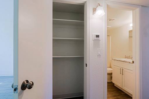 A white door with a silver handle is open to a bathroom.