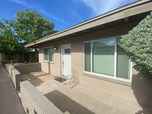 A house with a white door and a window with blinds.