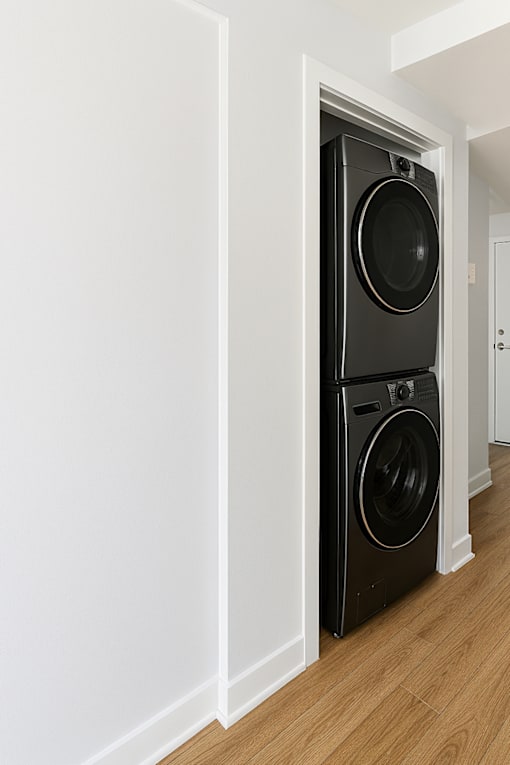 A black front loading washing machine in a white doorway.