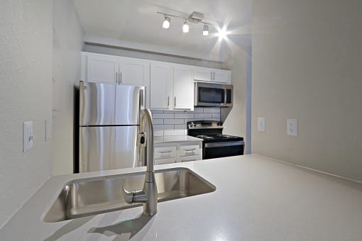 a kitchen and dining room with stainless steel appliances and a table and chairs