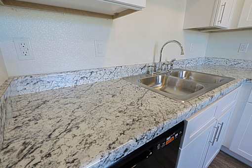 A kitchen counter with a sink and a dishwasher.