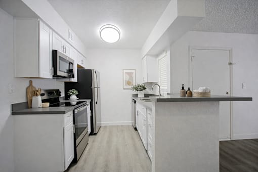 A kitchen with white cabinets and appliances.