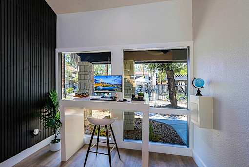 A room with a desk and a chair with a computer on it.