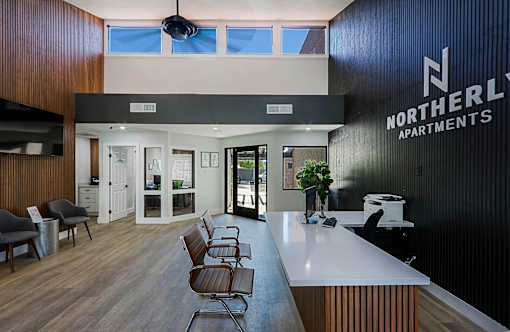 A lobby with a white counter and chairs.