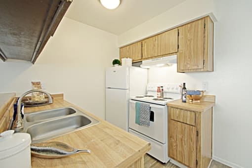 a kitchen with a white refrigerator freezer next to a white stove top oven