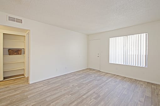 a bedroom with hardwood floors and a large window