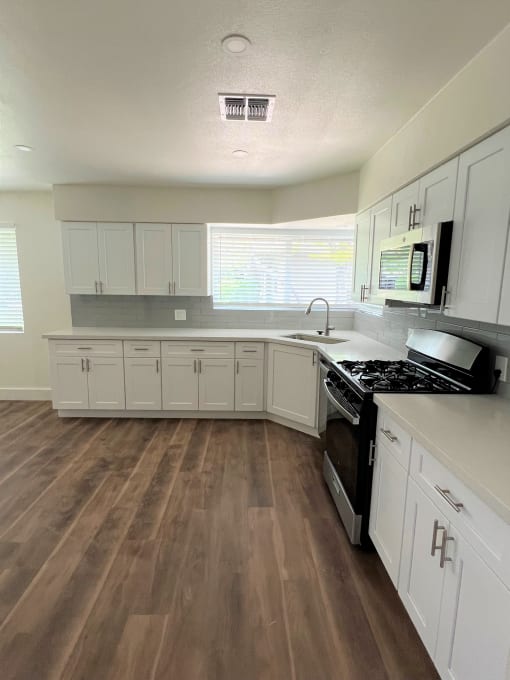 a kitchen with white cabinets and a black stove top oven