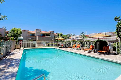 A swimming pool with chairs around it.