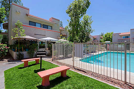 A pool surrounded by a fence and a bench.