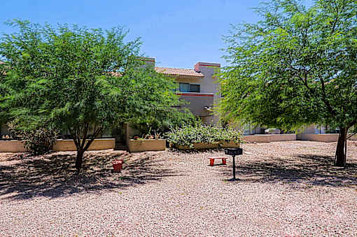 A house with a red roof and a gravel yard.