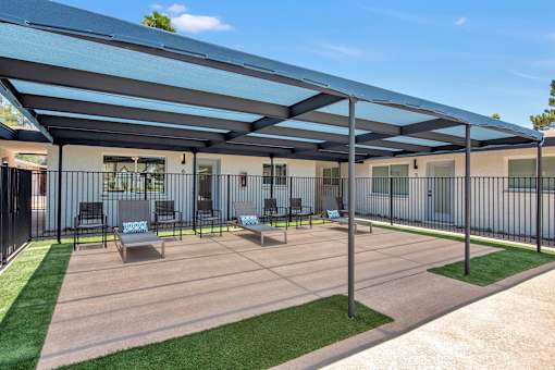A patio with a black fence and a grey roof.
