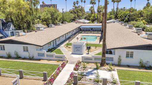A white building with a pool in front of it.