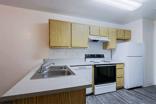 A kitchen with a white refrigerator, stove, and oven.