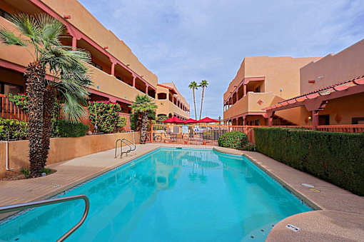 A swimming pool in a courtyard surrounded by buildings.