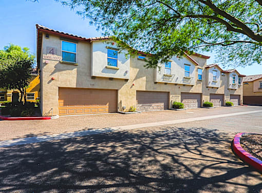 A row of houses with garages and driveways.