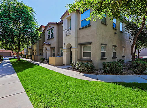 A row of houses with green lawns in front.