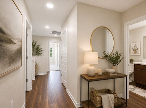A hallway with a table and a mirror.