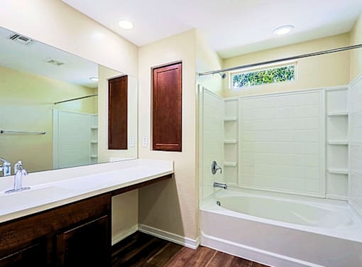 A bathroom with a white tub and sink.