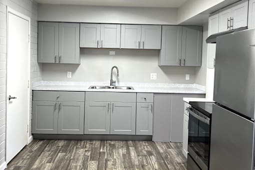 A kitchen with a sink and a refrigerator.