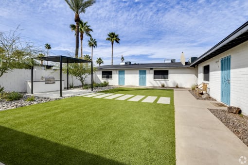 a white house with a yard and a blue door