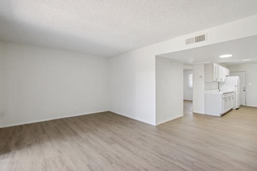 A room with wooden flooring and white walls.