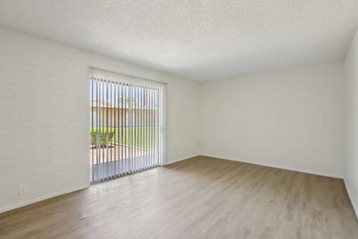 A room with a window and wooden flooring.