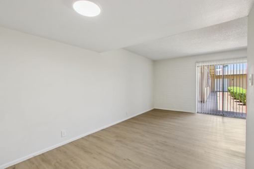 A room with wooden flooring and white walls.
