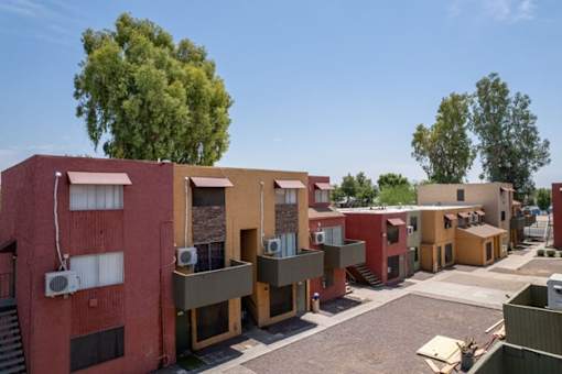A row of houses with a tree in the background.