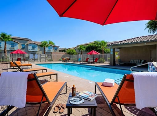 A poolside area with chairs and umbrellas.