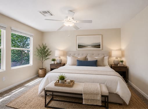 A bedroom with a large bed and a ceiling fan.