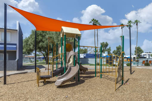 a playground with a slide and swings at a park