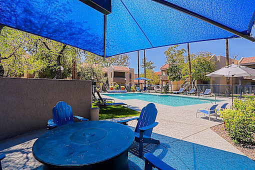 A blue table and chairs are set up under a blue canopy.