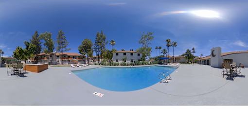 a swimming pool with chairs around it and a building in the background at Tides on McDowell, Phoenix, Arizona 85035