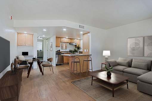 A modern living room with a kitchen in the background.