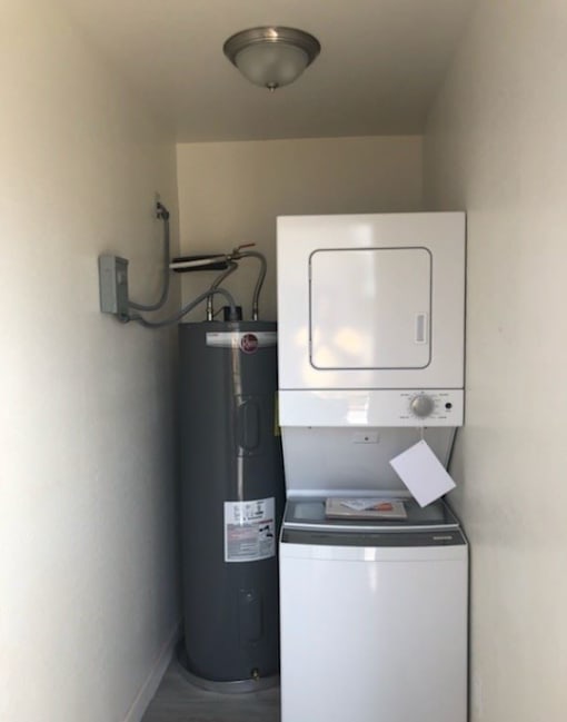 a small room with a refrigerator and a water heater