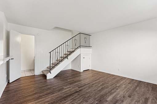 A room with a staircase and wooden floors.